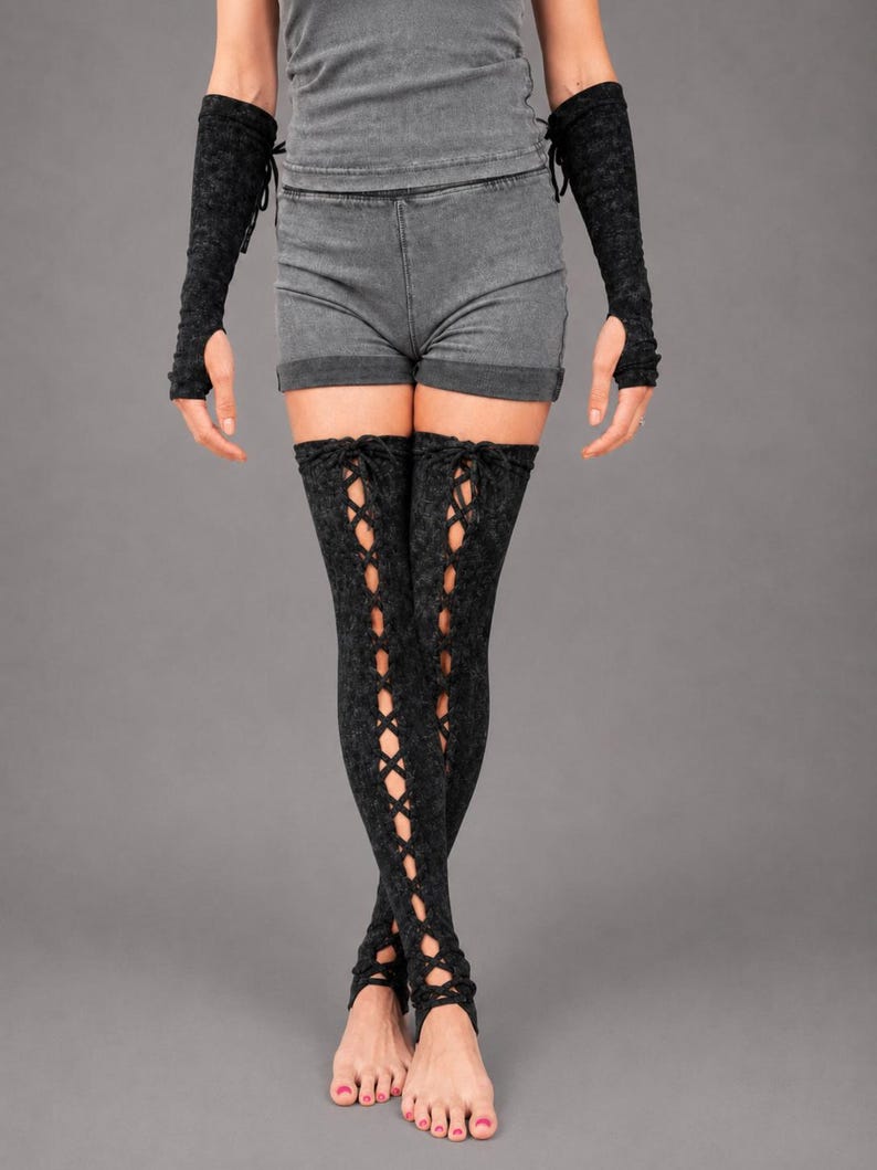 May include: A pair of black acid-wash thigh-high leg warmers featuring a vertical lace-up design with crisscross ties running down the front, paired with matching black acid-wash fingerless arm warmers that extend to the mid-forearm.