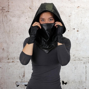 May include: A black leather hooded cowl with a pointed tip. The cowl covers the face and neck, and has a long, flowing hood.