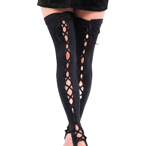 May include: Black leggings with a lace-up design on the sides. The leggings extend to the upper thigh and feature a tie at the top. The open design reveals the skin. The leggings are made of a soft, stretchy material.