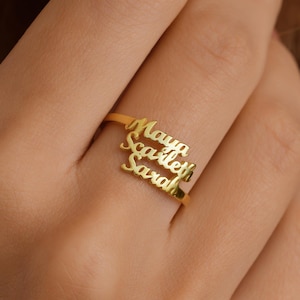 May include: Gold ring with three names engraved on it: Maya, Scarlett, and Sarah.