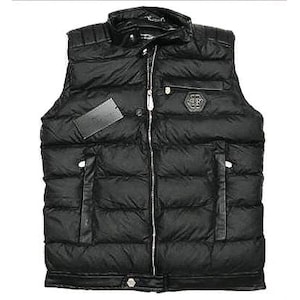 Peut inclure: Veste matelassée noire avec col montant et fermeture éclair intégrale. Comprend des empiècements en cuir sur les poches et le col, ainsi qu'un petit écusson logo sur la poitrine. Une étiquette noire est attachée.