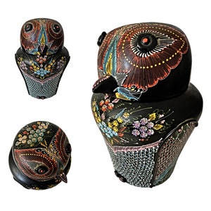 Peut inclure: Figurines de hibou en céramique noire peinte à la main avec des motifs floraux colorés et des détails complexes. Le hibou a de grands yeux et un bec, et est une pièce décorative pour une maison ou un bureau.