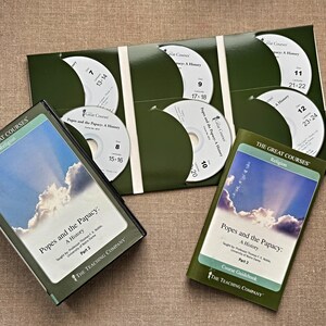以下が含まれることがあります： 「The Great Courses」の宗教に関する教材セット。緑色のケースに複数のCDと2冊のガイドブックが入っています。「Popes and the Papacy: A History」というタイトルが見えます。