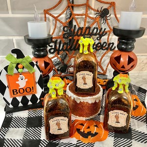 May include: Halloween-themed decorations featuring orange and black pumpkins, a spider web, and bottles labeled "Zombie Brew." The scene includes a "Happy Halloween" sign, a "Boo!" sign, and decorative candles.