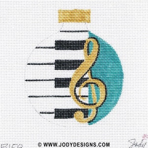 May include: A teal and gold Christmas ornament with a piano keyboard and a treble clef. The ornament is decorated with a gold top and the text "www.jodydesigns.com".