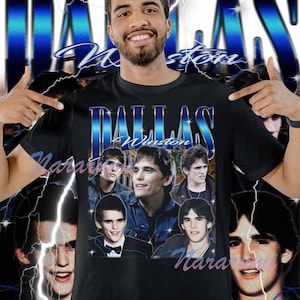 May include: Black t-shirt with a retro design featuring the text "DALLAS Winston" in blue and white. The shirt includes a collage of images and a lightning bolt design, giving it a vintage look.