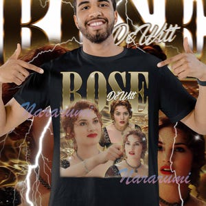 May include: Black t-shirt with a gold-coloured graphic of the name "Rose DeWitt" and images of a woman. The design includes a lightning bolt and a watermark.