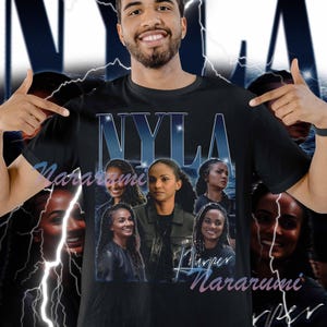 May include: Black t-shirt featuring the name "NYLA" in a stylized font with a blue gradient. The shirt displays multiple images of a woman, with the name "Harper Nararumi" in a script font below the images. The background has a dark blue gradient with lightning bolts.