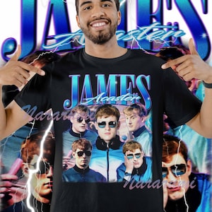 Puede incluir: Camiseta negra con un diseño retro azul y blanco con el texto "JAMES Acaster" y un gráfico de un grupo de personas con gafas de sol. La imagen tiene una estética vintage con acentos de rayos.