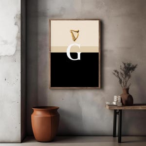 Minimalist art print inspired by Guinness branding, featuring a large letter G in black and cream tones, styled in a modern interior setting