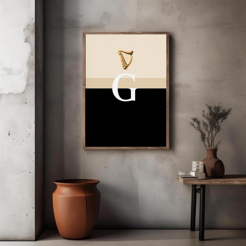 Minimalist art print inspired by Guinness branding, featuring a large letter G in black and cream tones, styled in a modern interior setting