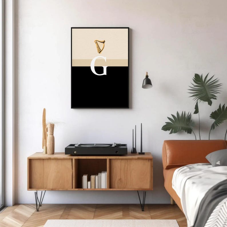 Minimalist art print inspired by Guinness branding, featuring a large letter G in black and cream tones, styled in a modern interior setting