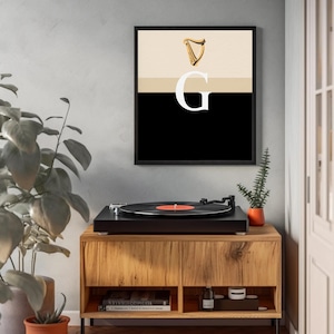 Minimalist art print inspired by Guinness branding, featuring a large letter G in black and cream tones, styled in a modern interior setting