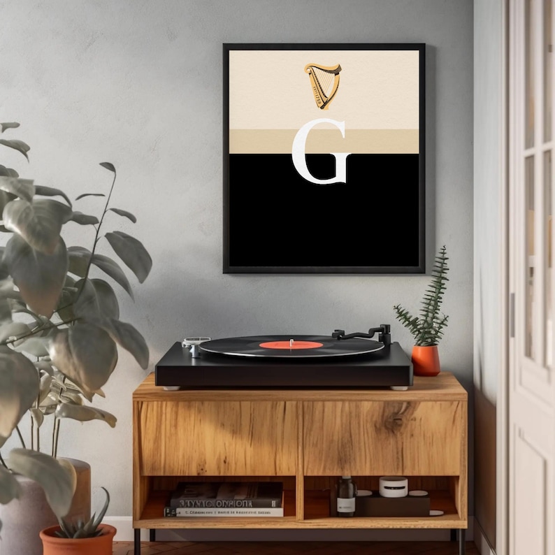 Minimalist art print inspired by Guinness branding, featuring a large letter G in black and cream tones, styled in a modern interior setting