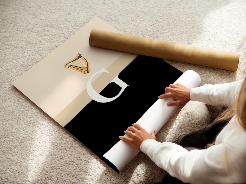 Minimalist art print inspired by Guinness branding, featuring a large letter G in black and cream tones, styled in a modern interior setting