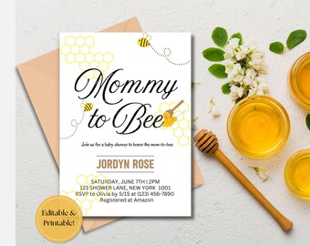 May include: A white baby shower invitation with a yellow honeycomb pattern and a black and white graphic of a bee. The text "Mommy to Bee" is in a black cursive font. The invitation includes the name "Jordyn Rose" and details for the baby shower.