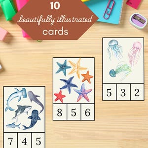 May include: Ten printable cards featuring colorful illustrations of sea creatures and numbers. The cards are designed for learning math and counting. The text on the cards reads "10 beautifully illustrated cards" and "PRINT INSTANTLY!"