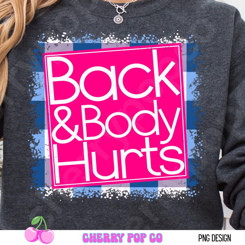 May include: Dark gray sweatshirt with a pink square featuring the words "Back & Body Hurts" in white. The design is set against a blue and white plaid pattern. The sweatshirt has a crew neck.