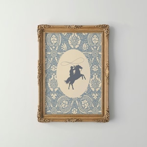 Puede incluir: Una impresión enmarcada con un fondo estampado en azul y blanco. La impresión presenta una silueta de un vaquero montando un caballo y lanzando un lazo.