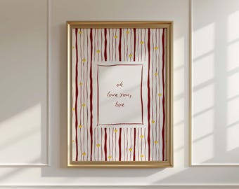 May include: A framed art print with a gold frame. The artwork features a white background with a red and white striped pattern and small yellow hearts. The center has a white rectangle with the words "ok love you, bye".