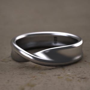 May include: A silver ring with a twisted design. The ring is smooth and polished.