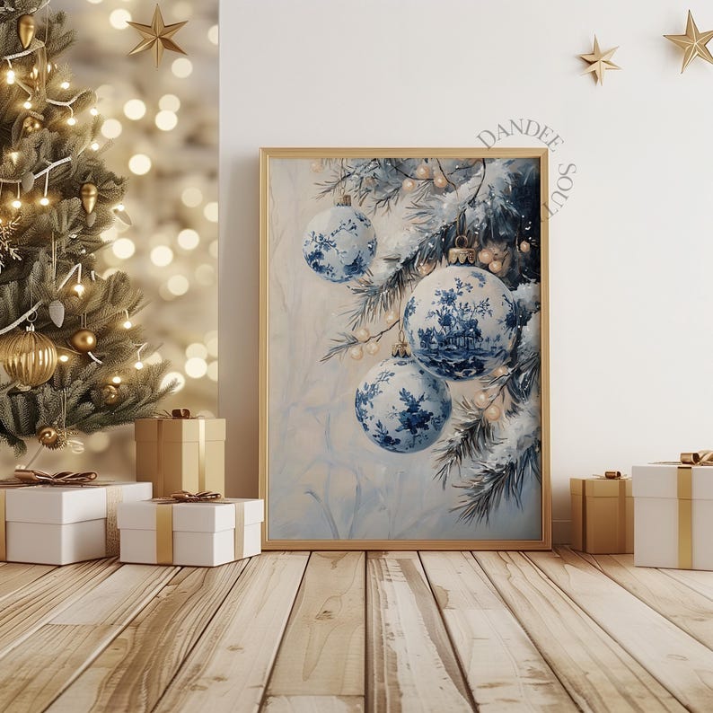 May include: A framed print featuring blue and white Christmas ornaments with floral designs. The ornaments hang on a snowy pine branch. The print is in a gold frame and is displayed near a decorated Christmas tree and wrapped gifts.
