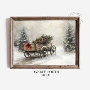 May include: A framed print depicts a winter scene with a wooden wagon carrying a Christmas tree, tied with red ribbons. Snow falls around the wagon and evergreen trees. The print is labeled "DANDEE SOUTH PRINTS".