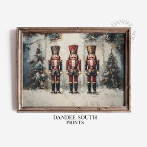 May include: A framed print featuring three toy nutcracker soldiers in a snowy forest scene. The nutcrackers are dressed in red, blue, and gold uniforms. The print has the text "DANDEE SOUTH PRINTS" at the bottom.