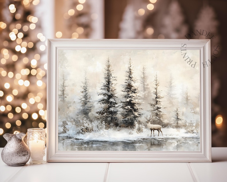 May include: A framed winter landscape painting featuring a serene forest scene with snow-covered trees and a deer standing near a body of water. The artwork is in a white frame, evoking a sense of tranquility and the beauty of nature.