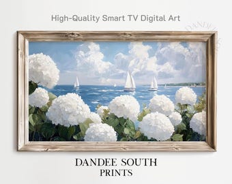 May include: A framed digital art print featuring a coastal scene with white sailboats on a blue sea under a cloudy sky. White hydrangea flowers are in the foreground. The text "High-Quality Smart TV Digital Art" and "DANDEE SOUTH PRINTS" are visible.