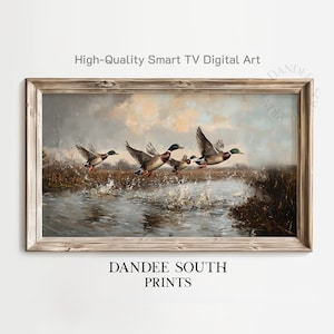 May include: A framed print of a vintage painting featuring a flock of ducks taking flight over water. The artwork has a rustic wooden frame and the text "High-Quality Smart TV Digital Art" and "DANDEE SOUTH PRINTS".