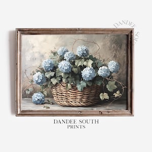 May include: A framed painting of a wicker basket filled with blue hydrangeas. The basket is sitting on a wooden table with a light brown background.