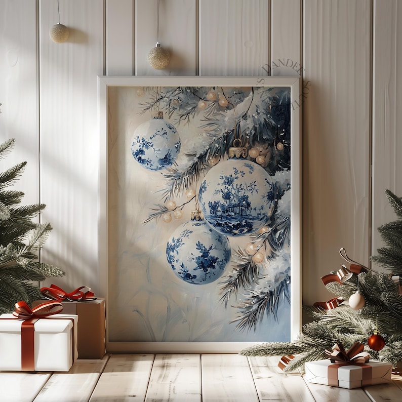 May include: A framed print featuring blue and white Christmas ornaments with a floral design. The ornaments hang from a snowy pine branch. The print is displayed on a wooden surface with gift boxes and a Christmas tree.
