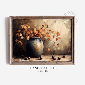 May include: A framed print of a still life painting featuring a dark blue vase filled with orange and yellow leaves and berries. The painting has a rustic, vintage style with a neutral background. The text "DANDEE SOUTH PRINTS" is at the bottom.