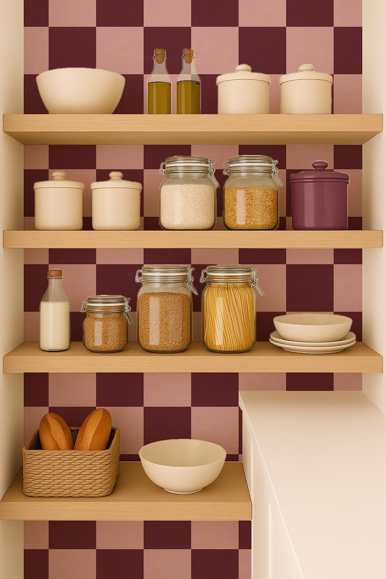 Puede incluir: Una despensa con estantes de madera que exhiben varios alimentos. Se ven frascos de granos y pasta, cuencos y botellas de aceite. Una cesta de pan y un cuenco est&aacute;n en el estante inferior. El fondo presenta un patr&oacute;n de cuadros en borgo&ntilde;a y rosa.