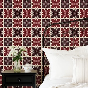 May include: A white bed with a white headboard and a white duvet cover. The headboard is made of metal and has a decorative design. The bed is in front of a wall with a red and brown geometric pattern wallpaper.