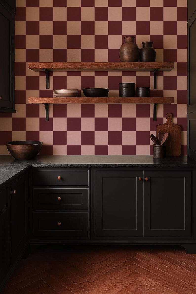 Puede incluir: Interior de cocina con pared a cuadros burdeos y beige. Estantes de madera con cer&aacute;mica y cuencos. Armarios negros con pomos de cobre y una tabla de cortar de madera. El suelo tiene un patr&oacute;n de espiga.