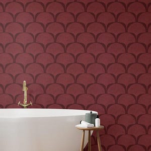 Pu&ograve; includere: Un bagno con una parete bordeaux con un motivo ripetuto a forma di ventaglio marrone scuro. Una vasca da bagno bianca e uno sgabello in legno con articoli da toeletta sono in primo piano. Un rubinetto dorato &egrave; montato a parete.