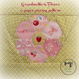 May include: A paper piecing pattern titled "Grandmother's Flower" featuring a floral design. The flower is composed of pink and yellow fabric with various patterns, including cherries, bunnies, and bows. The background is yellow with a small white dot pattern.