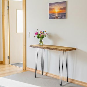 Handgjort sidobord i naturligt askträ med livlig kant, passar bakom en soffa