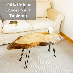 Unique live edge wood centerpiece with warm tones, made from solid timber, wax-sealed and mounted on black metal legs for contrast.