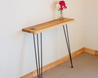 Minimalistyczny stolik kawowy, zasilany z konsoli za kanapą, smukła półka na grzejnik z drewna jesionowego