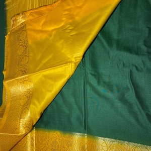 May include: A green and yellow saree with a gold border. The saree is made of a soft, silky fabric and has a traditional design.