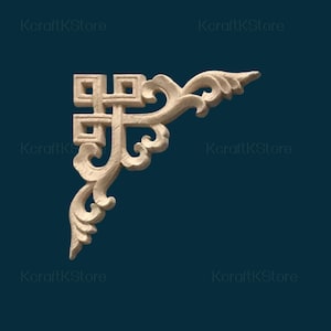 May include: A light-colored, wooden corner molding with an ornate, scrollwork design. The decorative element features a square-shaped top with a cross-like pattern and flowing, curved details. The background is a dark teal color.