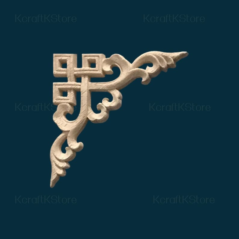 May include: A light-colored, wooden corner molding with an ornate, scrollwork design. The decorative element features a square-shaped top with a cross-like pattern and flowing, curved details. The background is a dark teal color.