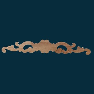 K&ouml;nnte beinhalten: Ein dekorativer Holzleiste mit einem geschnitzten, verzierten Design. Die Leiste ist hellbraun und hat ein zartes, filigranes Muster.
