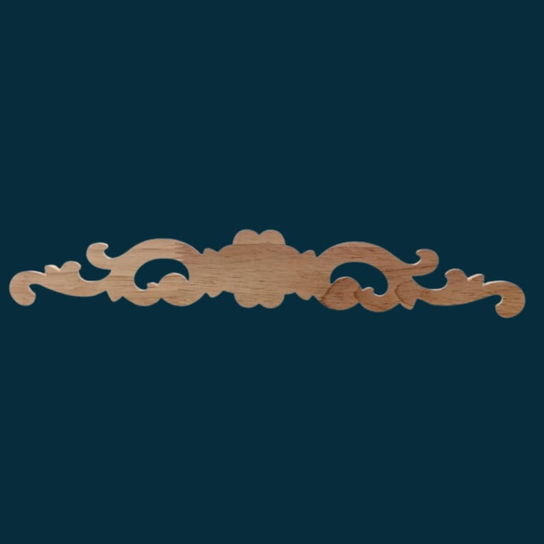 K&ouml;nnte beinhalten: Ein dekorativer Holzleiste mit einem geschnitzten, verzierten Design. Die Leiste ist hellbraun und hat ein zartes, filigranes Muster.