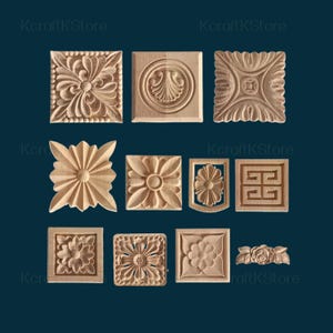 Può includere: Una collezione di undici elementi decorativi in legno intagliato. I disegni includono motivi floreali, forme geometriche e motivi stilizzati. I pezzi sono esposti su uno sfondo blu scuro, mettendo in risalto la venatura naturale del legno.