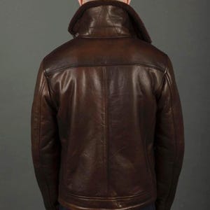 Puede incluir: Chaqueta de cuero marr&oacute;n con cuello de borrego. La chaqueta tiene un dise&ntilde;o cl&aacute;sico con cremallera frontal y un aspecto c&aacute;lido y acogedor. La vista trasera muestra el ajuste entallado y el color intenso de la chaqueta.