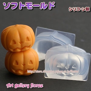 Pode incluir: Dois moldes de silicone laranja em forma de abóbora com um design de rosto de jack-o'-lantern. Os moldes são feitos de silicone transparente e estão sobre uma superfície branca. O texto "Art gallery floree" está impresso na superfície.